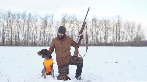 hunter likes his dog. handsome man looking at his tired dog after hunting.
