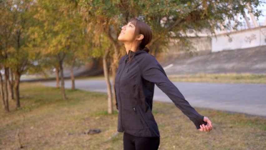 Beautiful woman breathing in the fresh morning air on her run, slow motion. 