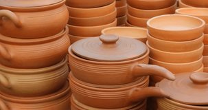 Terra cotta cookware. with handles and lids. neatly stacked and displayed for sale at a public market in the Republic of Georgia. Video DCI 4k