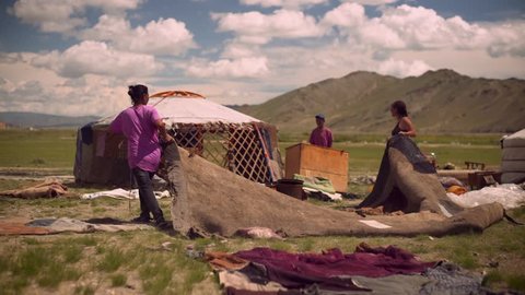 Mongolian nomad people set up a new ger, traditional tent house, in the mountains of West Mongolia.
