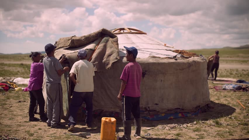 Mongolian nomad people set up a new ger, traditional tent house, in the mountains of West Mongolia.