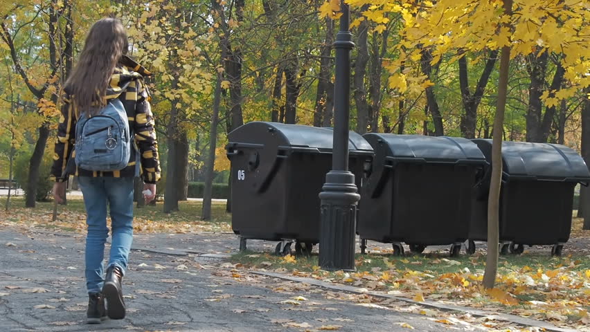 The child throws garbage. The girl throws garbage in the trash.