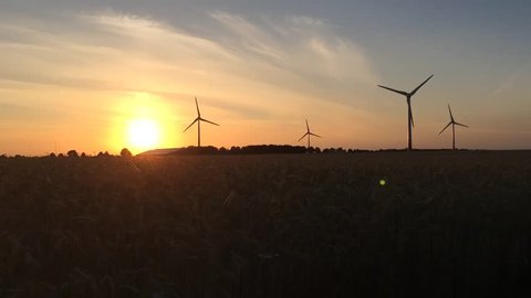 Beautiful sunset with spinning wind turbines in northern Germany