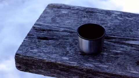 Hot tea from a thermos during a mountain journey. Close up.