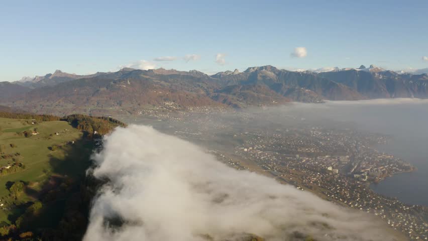 Aerial of patch of fog climbing and dissipating fast over forest and farm fields. Montreux, Vevey and Lake Léman below the mist
Mont Pélerin - Vaud - Switzerland