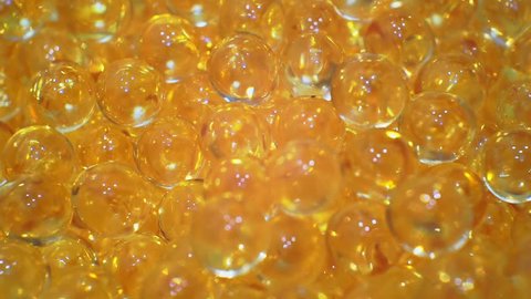 soft gelatin capsules close-up.fish oil capsules.Pharmaceutical production.
moving background.shallow depth of field.macro shooting.