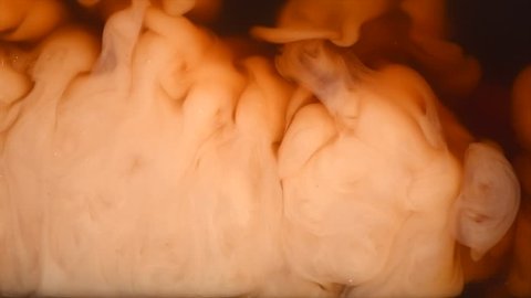 Abstract milk in coffee or tea background. Beautiful Backdrop of Dropping cream in black coffee, Added Creamer, cream swirling in coffee. 4K Slow motion video