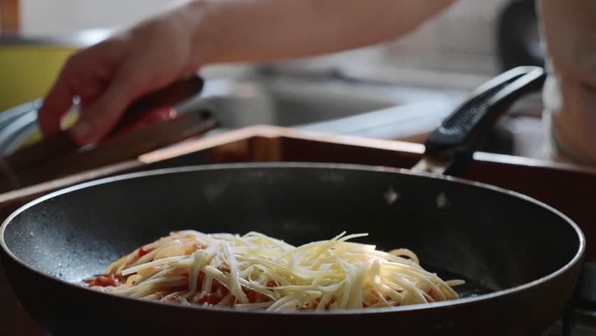 Cooking and stirring the spaghetti with red tomato sauce in the frying pan, close-up in slow motion | Shutterstock HD Video #1021204654