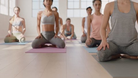 attractive yoga class instructor leading group meditation teaching healthy women childs pose enjoying exercising in fitness studio practicing posture at sunrise