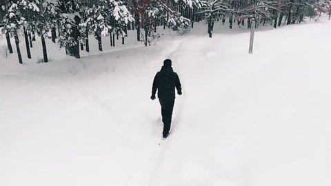 Lone Man Walking Through Snow
