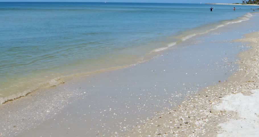 The waves on the beach of the gulf of mexico in Florida. Beach scene with white sand and blue / aqua water.