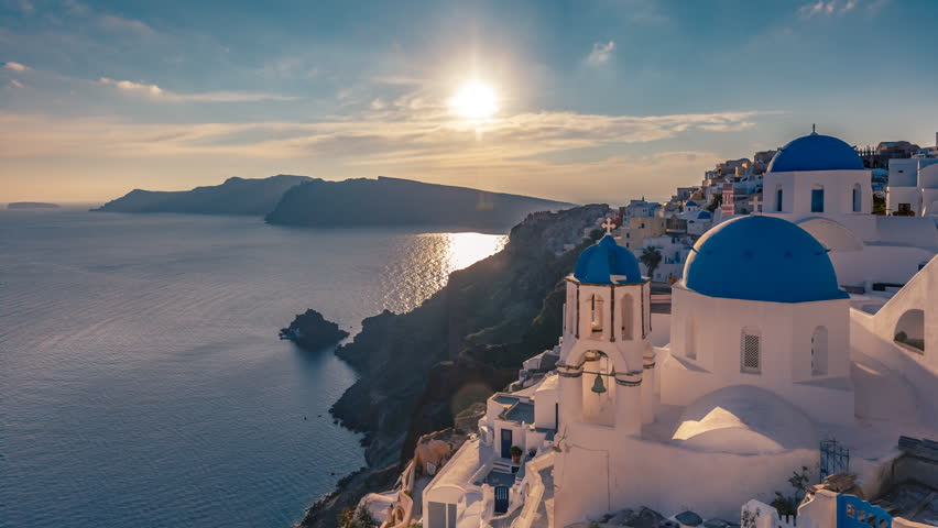 Beautiful view of Churches in Oia village, Santorini island in Greece at sunset, with dramatic sky. 4K day to night transition timelapse. | Shutterstock HD Video #1021211371