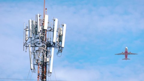 Telecommunication(5G)tower and plane on sky background.Concept of network connectivity and signaling around the world.Digital cellular telephone.Antenna.Communication.High technology.