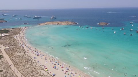 Drone flying over the blue turquoise beach of Formentera, Ibiza a popular European holiday destination.