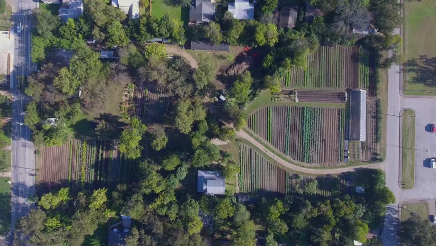 AERIAL: Still areal shot showing entire size of working farm with traffic driving by.