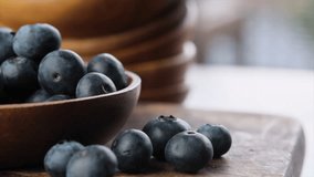 Close up footage of blueberry fruits in wooden bowl. Selective focus.