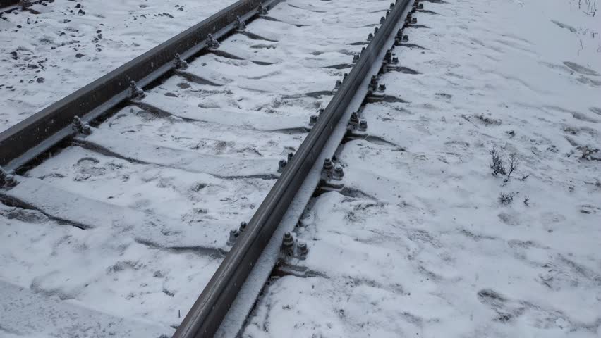 Railway tracks under the snow. Railway in winter. Empty railway track.