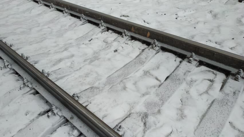 Railway tracks under the snow. Railway in winter. Empty railway track.
