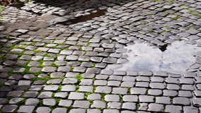 Cross of a dome of a church reflected on a puddle on paving in blocks of stone, in a cloudy day - Powered by Shutterstock - Get 15% off with code: PIKWIZARD15