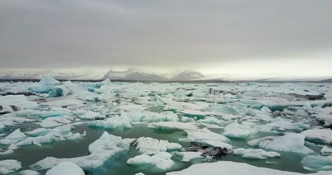 flying over iceberg in water, melting glacier, climate change