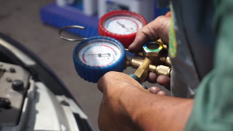 Car Air Conditioner Check Service, System Refrigerant Recharge Or Fill, Leak Detection. Auto Mechanic Uses a Pressure Gauge On The Air Compressor, Liquid Air Pressure.