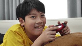 Asian boy playing video game at home .4K Slow motion