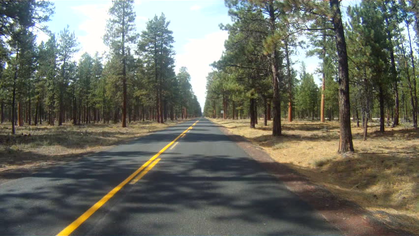 A car moves up the road towards windy ridge in rural Oregon