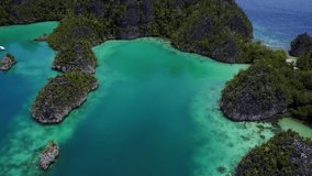Dramatic drone footage flying above the tropical coast of Raja Ampat, Indonesia and over a mountain