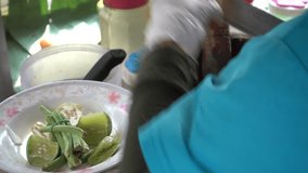 Hand of street vendor is cooking green papaya salad Thai cuisine spicy 