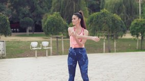 Slowmotion video of Runner fit woman warming up before sport training in the park.