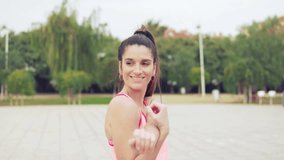 Slowmotion video of Runner fit woman warming up before sport training in the park.
