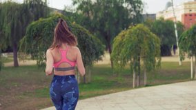 Slowmotion video of fit woman running in the park . morning sport training