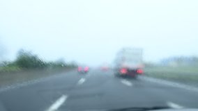 Blurred video of a car traveling on a highway during a rainy day.