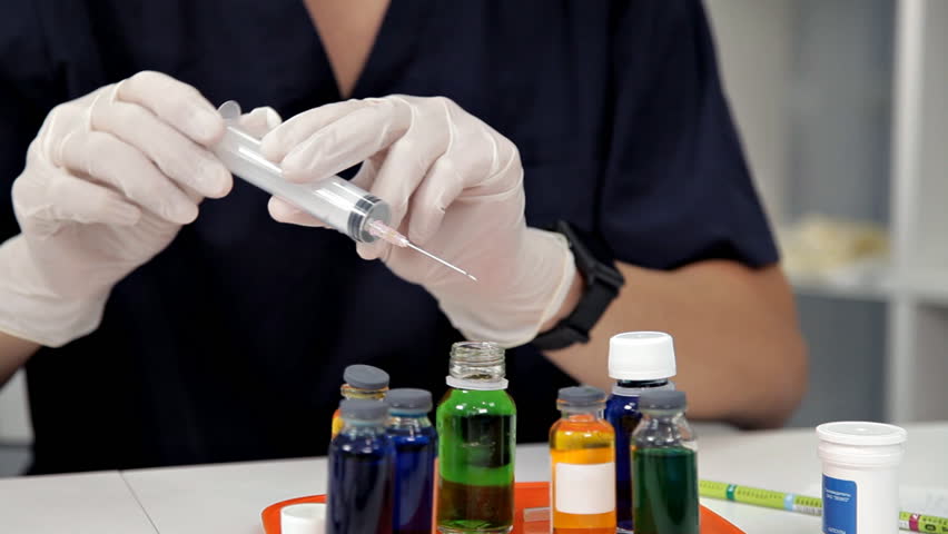 A doctor or scientist in laboratory holding a syringe with liquid vaccines for children or older adults, or cure animal diseases. Concept:diseases,medical care,science, anesthesia,euthanasia,diabetes Royalty-Free Stock Footage #1021275895
