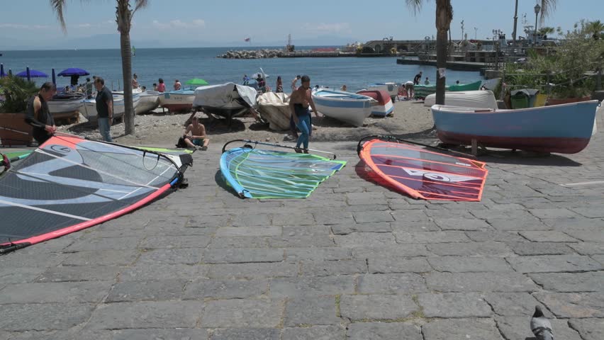 Vertical pan of young man maintaining his windsurf sail