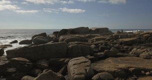 4K summer day aerial drone footage of spectacular popular bathing Saunders Rock's Beach, residential suburb of Cape Town on the Atlantic seaboard of the Cape Peninsula in Western Cape in South Africa