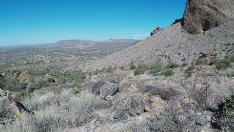Apache Junction, AZ / USA - July 12, 2018: Zoom in shot to hikers at Lost Dutchmen State Park. People make their ascent along trail to the Superstition Mountain Peak.