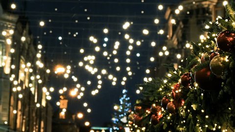 Outdoor light bulbs are swinging on the wires from the wind. Moscow city decorated for New year and Christmas celebration. Russia.