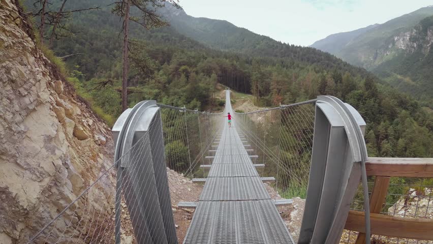People on a suspension bridge in the mountains near the village of Perarollo di Cadore.