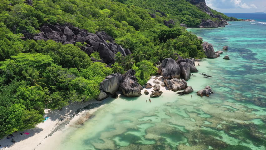 Aerial view of tropical paradise beach with white sand and turquoise crystal clear water of Indian Ocean - Anse Union, La Digue Island, Seychelles