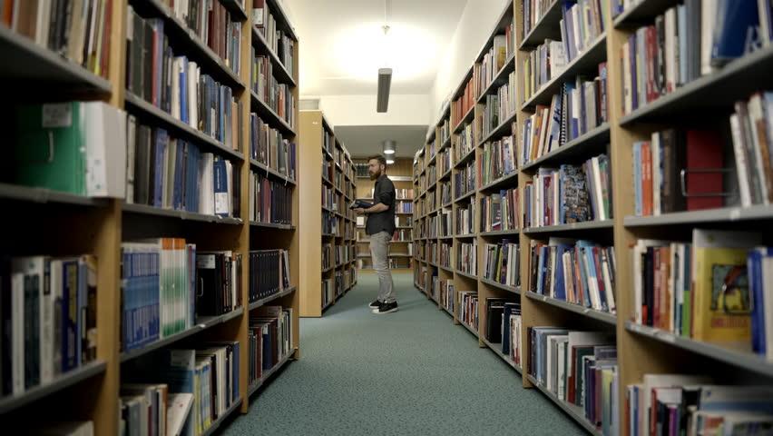 student in a public library, preparing her self for an exam Royalty-Free Stock Footage #1021324150