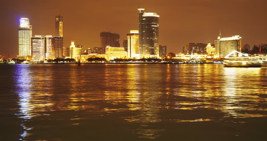 City night scene in Xiamen Fujian,China,luxurious cruise ship moving on the ocean,bright lights shining on the buildings