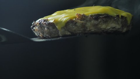 Ready hot burger cheese patty steamed lying on a shoulder blade, slow shooting