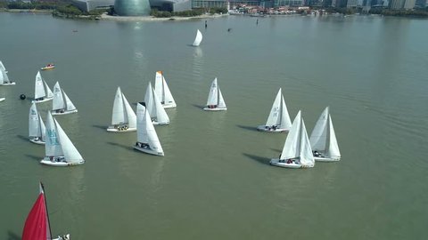 Suzhou, China - October 10, 2018: Aerial shot of sailing yachts at the race-regatta on the lake, cityscape on the background