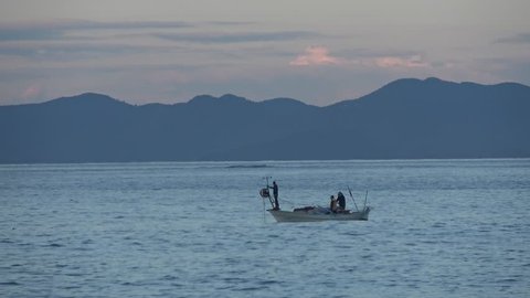 Calis beach, Fethiye, Turkey - 18th of December 2018: 4K Small fishing boat with a fisherman family on it at dawn
