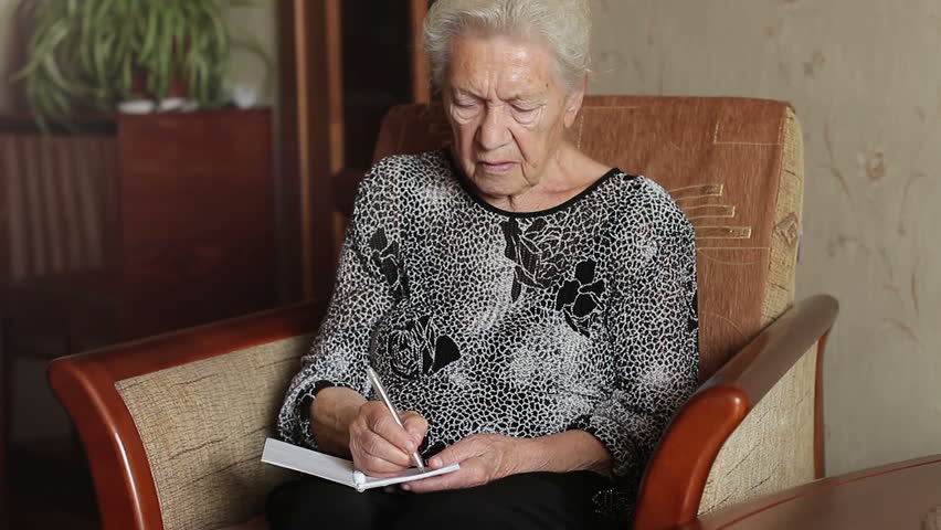 Old man's memory loss. An old woman trying to remember something and write in a notebook Royalty-Free Stock Footage #1021353937