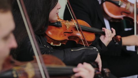 Violin concert. Musician playing violin outdoors. Violinist play music for the wedding. Violin under the open sky. Wedding music concept