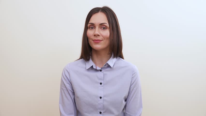 A young brunette rolls eyes, smiles, then puts on a serious look, and smiles slightly in the end