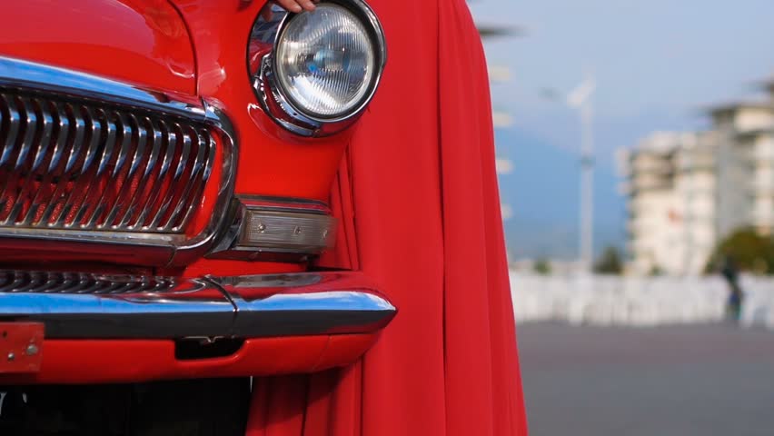 Beautiful woman in red dress, the lady is standing next to a red vintage car