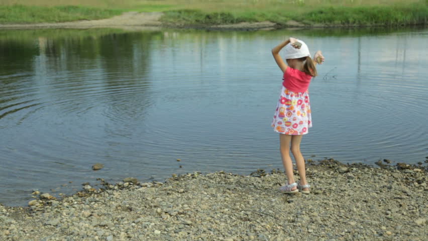Little girl throwing stones into water